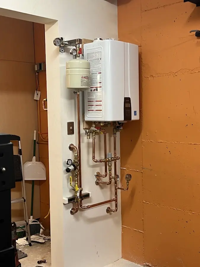 Plumbing technician inspecting water heater connections in Chadron